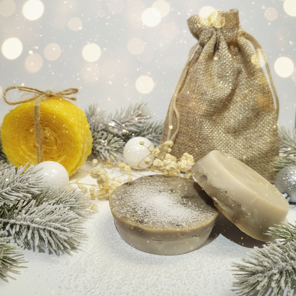 Two bars of soap with a burlap bag and yellow yarn on a white background