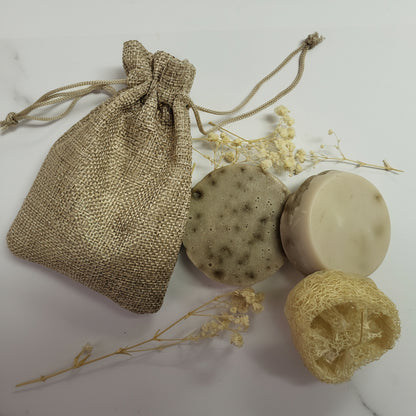 Natural soap with a drawstring bag and sponge on a light background